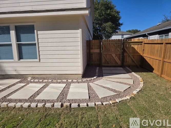 A house with a white siding and a brown fence.