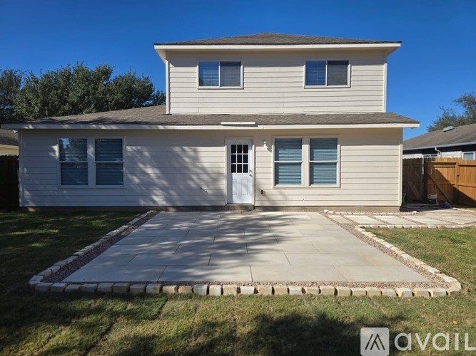 A two-story house with a front yard and a driveway.