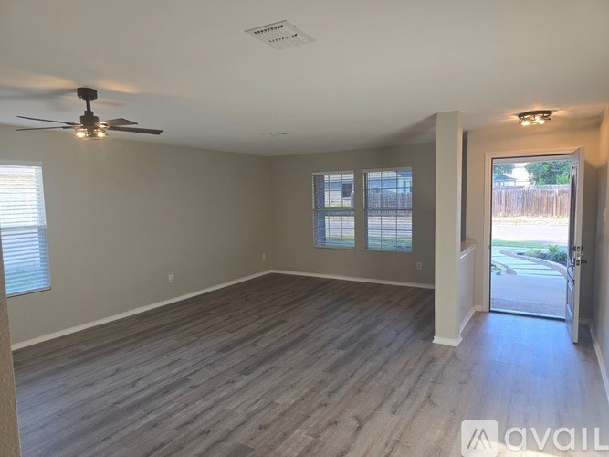 A room with a ceiling fan and wooden flooring.