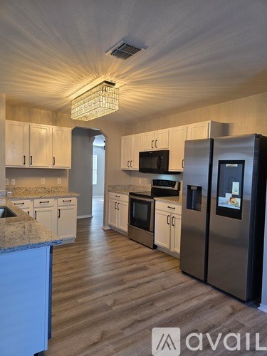 A kitchen with a granite counter top and stainless steel appliances.