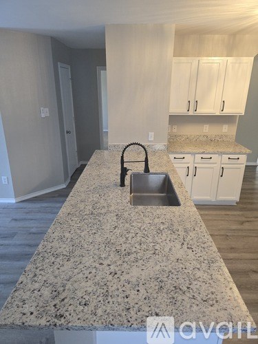 A kitchen with granite countertops and white cabinets.