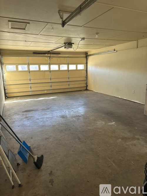 A large empty garage with a concrete floor and a yellow garage door.