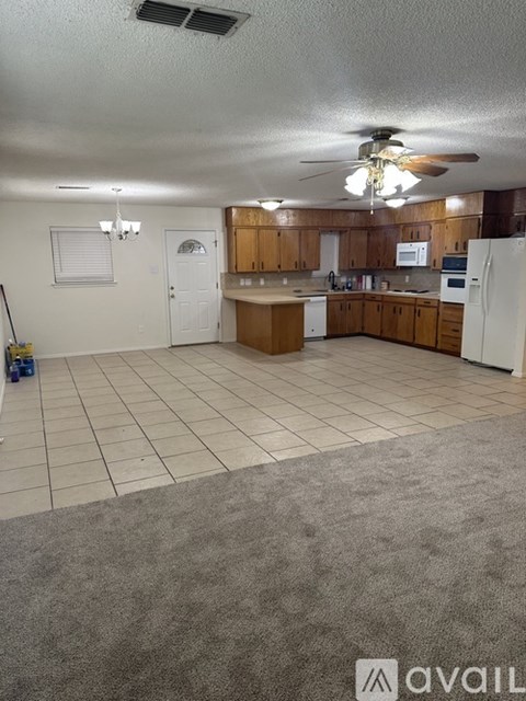 A kitchen with white appliances and wooden cabinets.