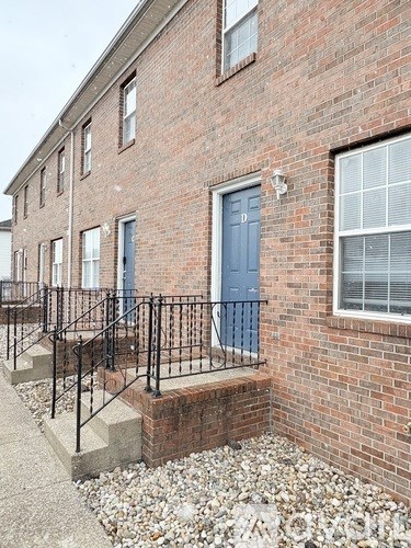 A brick building with a blue door and windows.