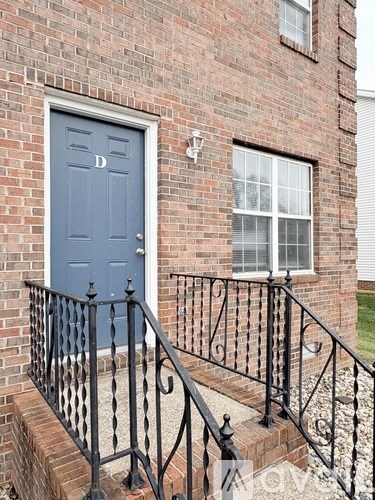 A blue door is on the left side of a brick building.