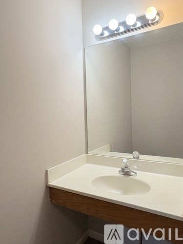 A bathroom sink under a mirror with lights above it.
