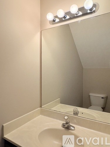 A bathroom with a sink, mirror, and toilet.