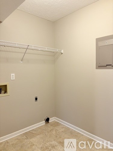 A room with a white wall and a shelf with a few items on it.