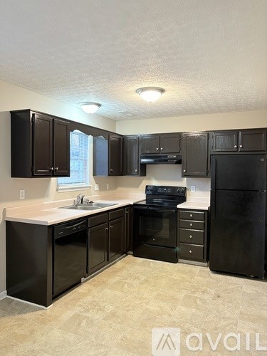 A kitchen with black cabinets and appliances.