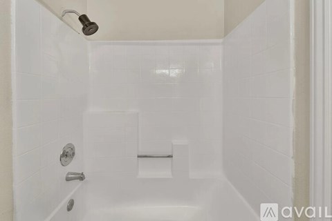 A white bathroom with a shower and a door.