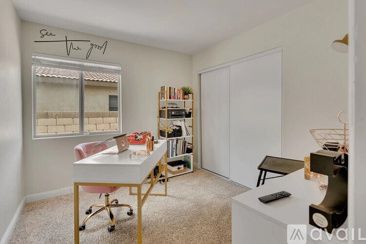 A room with a desk, chair, and bookshelf.