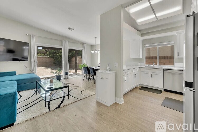 A modern kitchen with white cabinets and a dining table with chairs.
