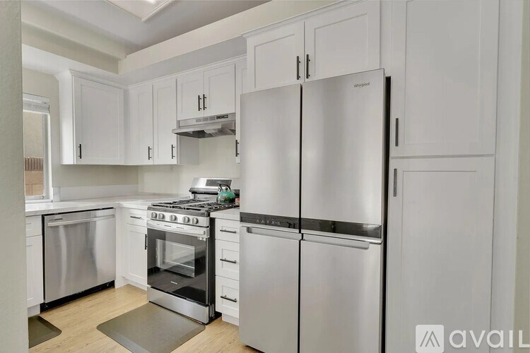 A kitchen with white cabinets and stainless steel appliances.