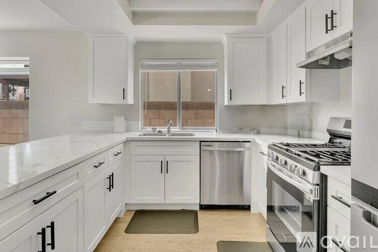 A kitchen with white cabinets and a stainless steel dishwasher.