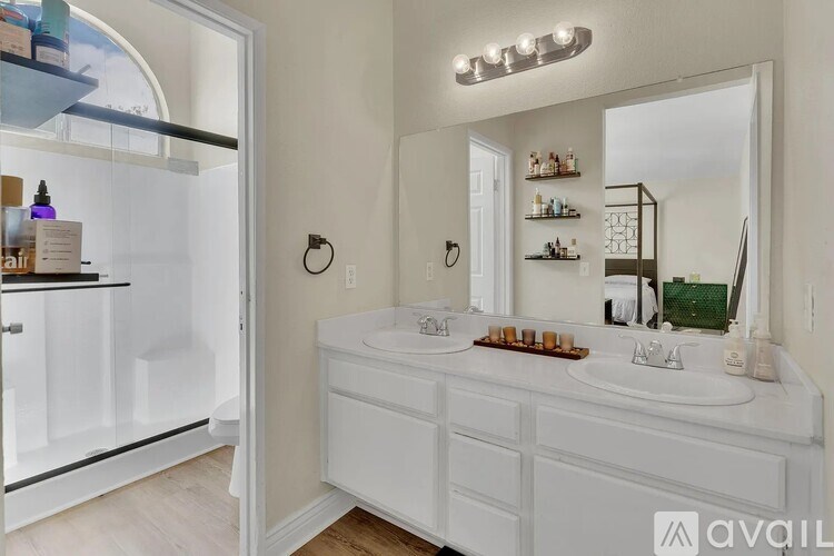 A bathroom with a white vanity and a mirror above it.