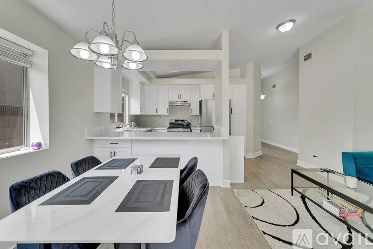 A modern kitchen with a dining table and chairs.