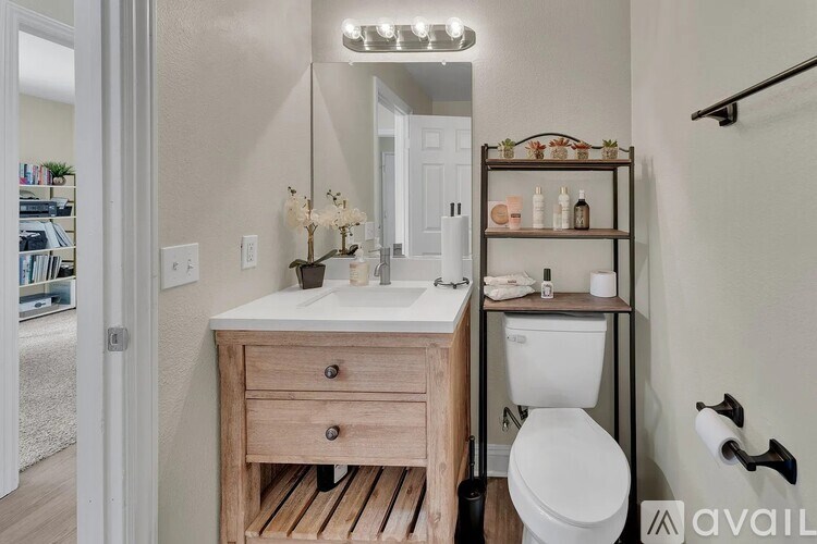 A bathroom with a white toilet and a wooden vanity.