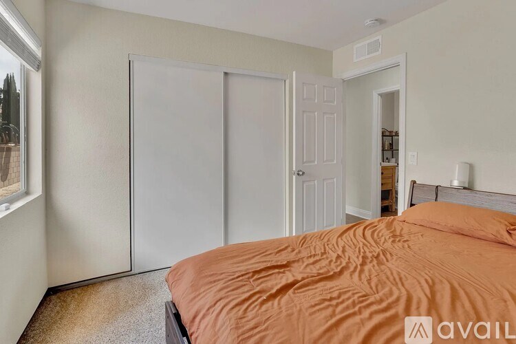 A bedroom with a bed, a window, and a closet.