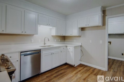 A kitchen with white cabinets and a stainless steel dishwasher.