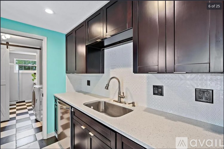 A kitchen with a checkered floor and a sink.