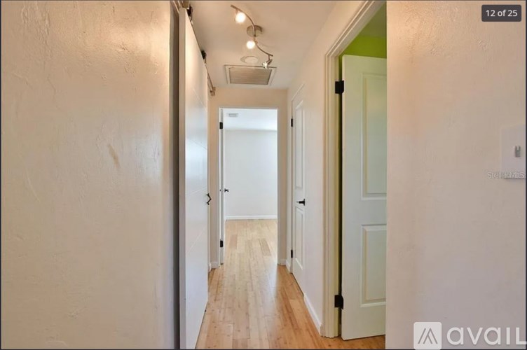 A hallway with a door on the right and a light on the ceiling.