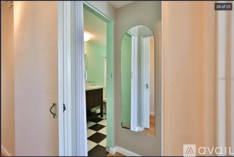 A bathroom with a white door and a mirror.