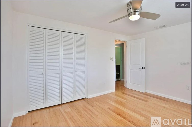 Closed white shutter doors in a room with a ceiling fan.