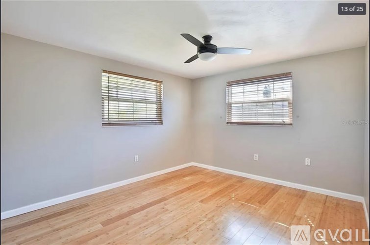 A room with wooden flooring and a ceiling fan.