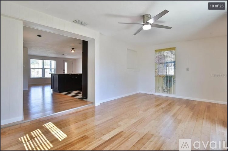A room with wooden floors and a ceiling fan.