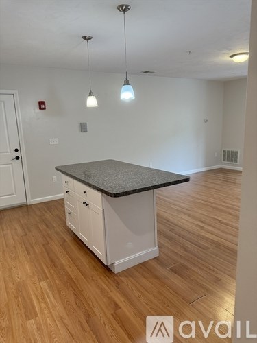 A kitchen with a granite countertop and white cabinets.