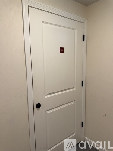 A white door with a red square on it.