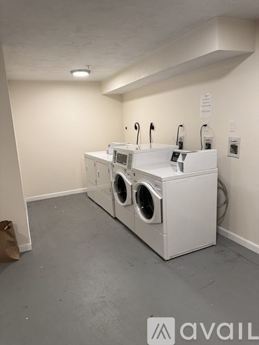 A room with a washing machine and a dryer.