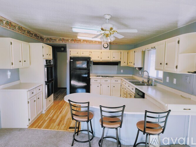 A kitchen with a table and chairs in front of it.