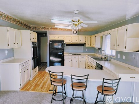 A kitchen with a table and chairs in front of it.