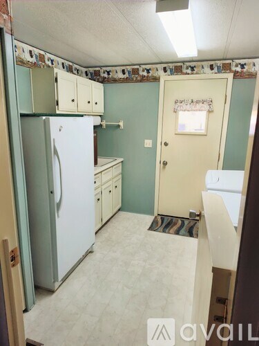 A kitchen with a white fridge and cabinets.
