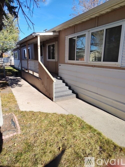 A mobile home with a brown and white exterior and a covered porch.