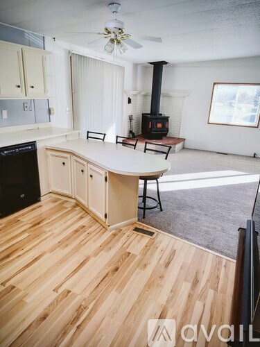 A kitchen with wood floors and a black stove.