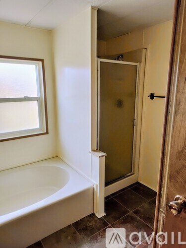 A bathroom with a tub and a door.