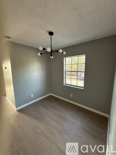 A room with a window and a light fixture on the ceiling.