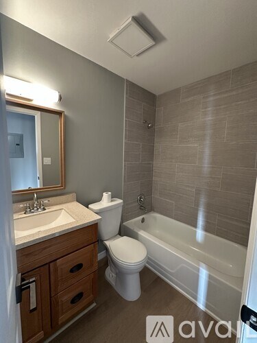 A bathroom with a toilet, sink, and bathtub.