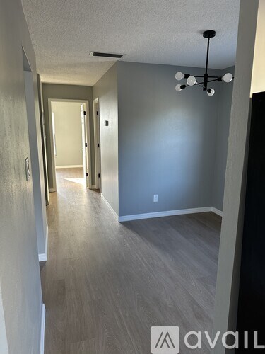 A hallway with a light fixture and a door at the end.