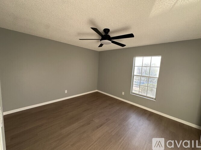 A room with a ceiling fan and a window.