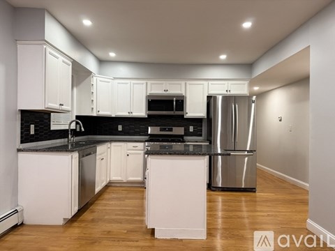 A modern kitchen with white cabinets and stainless steel appliances.