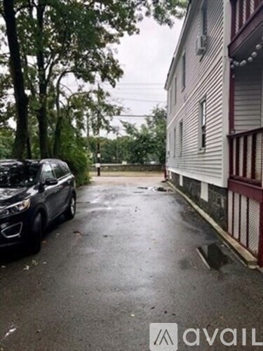 A car is parked on a driveway next to a house.