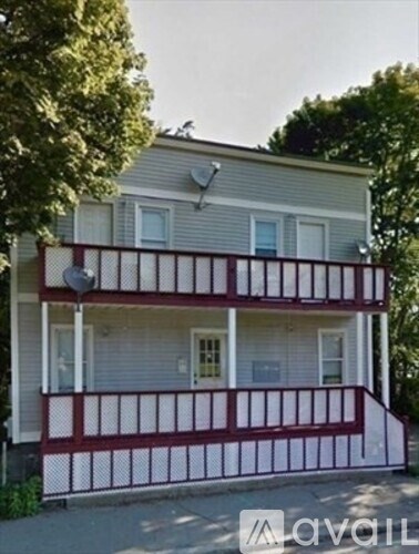 A two-story house with a red and white porch.