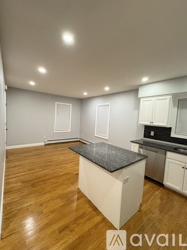 A kitchen with a granite countertop and wooden flooring.