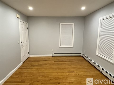 A room with wooden flooring and a white door.