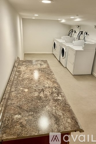 A bathroom with a marble counter top and white cabinets.