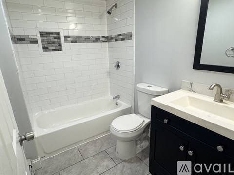 A bathroom with a white tub, toilet, and sink.