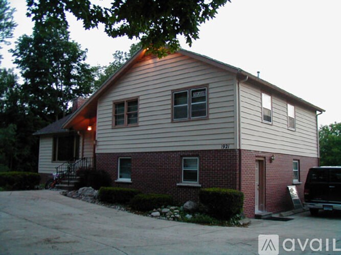 A house with a garage and a tree in front of it.
